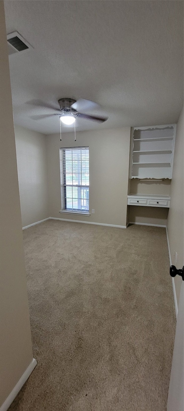 empty room featuring carpet, a textured ceiling, and ceiling fan