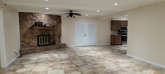 unfurnished living room featuring a fireplace, ornamental molding, light tile patterned floors, and ceiling fan