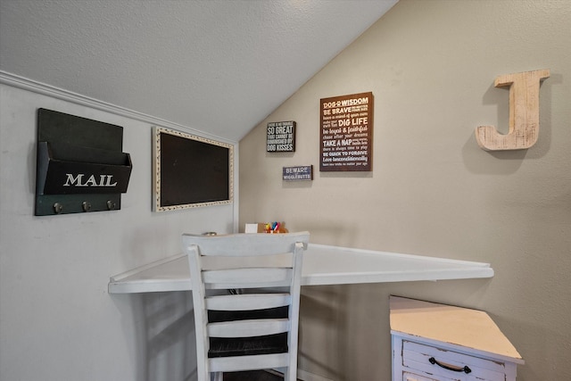 dining space featuring vaulted ceiling and a textured ceiling