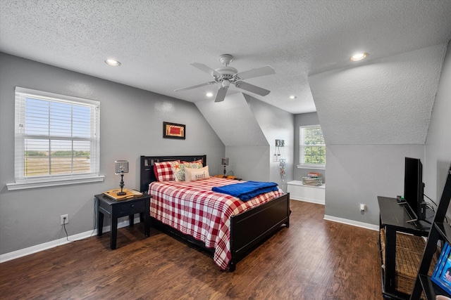 bedroom with a textured ceiling, ceiling fan, dark hardwood / wood-style flooring, and lofted ceiling