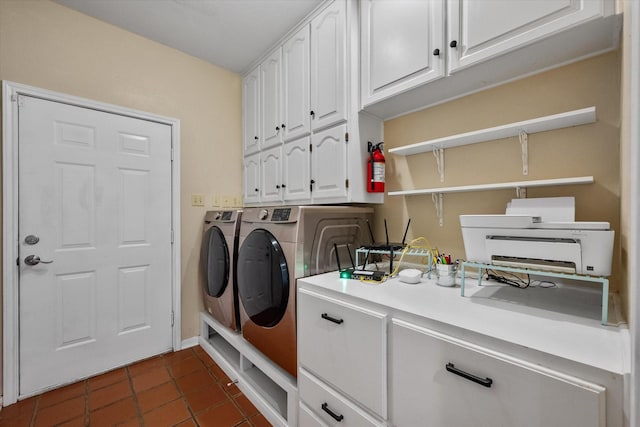 washroom with cabinets, dark tile patterned flooring, and washing machine and dryer