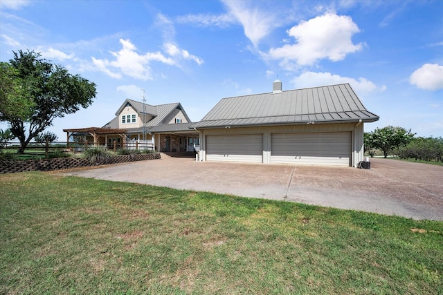 view of front of house with a garage, a front yard, and an outdoor structure