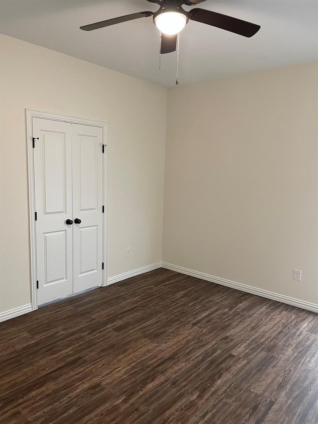 spare room with dark hardwood / wood-style floors and ceiling fan