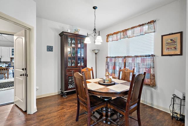 dining area with dark hardwood / wood-style floors and a chandelier