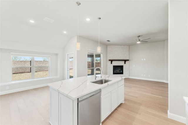 kitchen with sink, a kitchen island with sink, white cabinets, decorative light fixtures, and stainless steel dishwasher