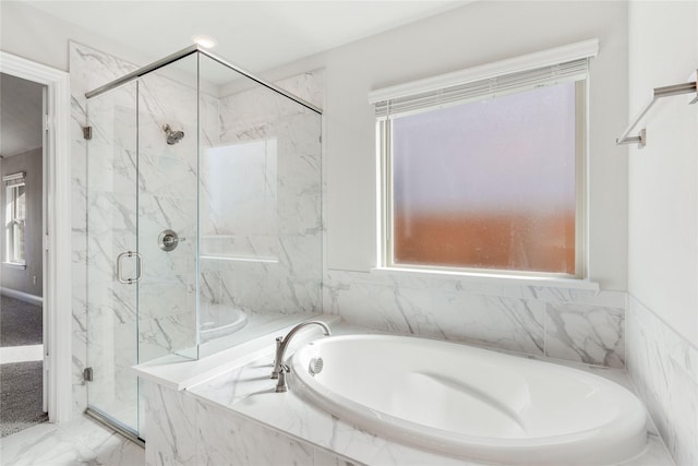 bathroom featuring plus walk in shower and plenty of natural light