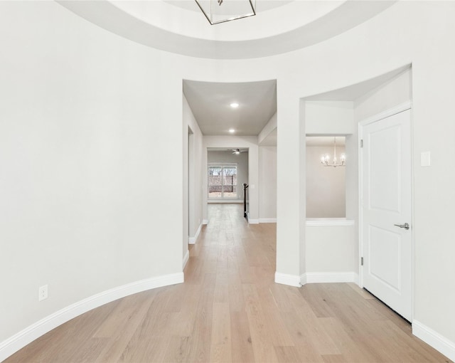 hall with a chandelier and light hardwood / wood-style flooring