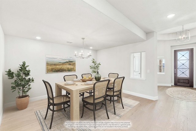 dining area featuring light hardwood / wood-style floors and a notable chandelier