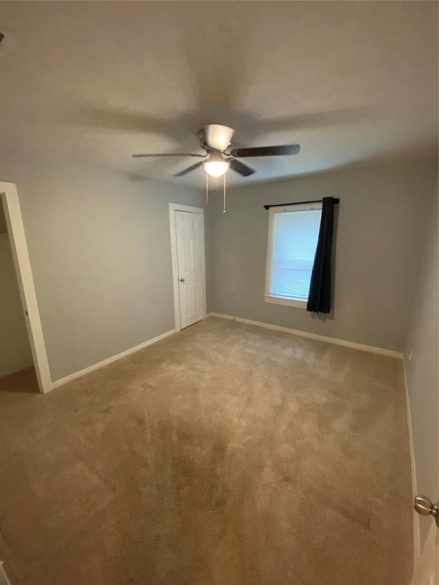 unfurnished room featuring ceiling fan and light colored carpet