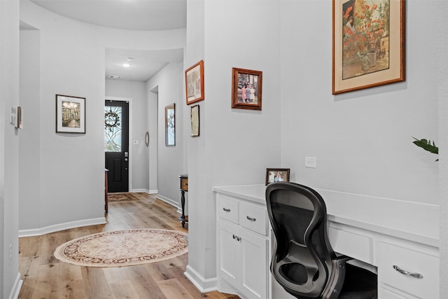 office featuring built in desk and light hardwood / wood-style floors