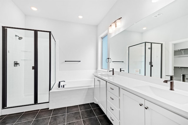 bathroom with tile patterned floors, a bath, a stall shower, and a sink