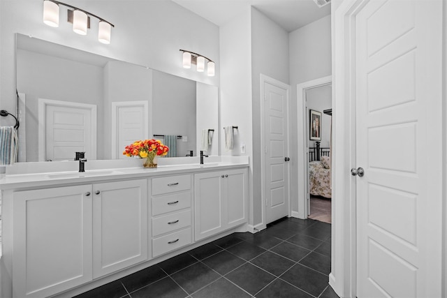 ensuite bathroom with a sink, double vanity, ensuite bathroom, and tile patterned flooring