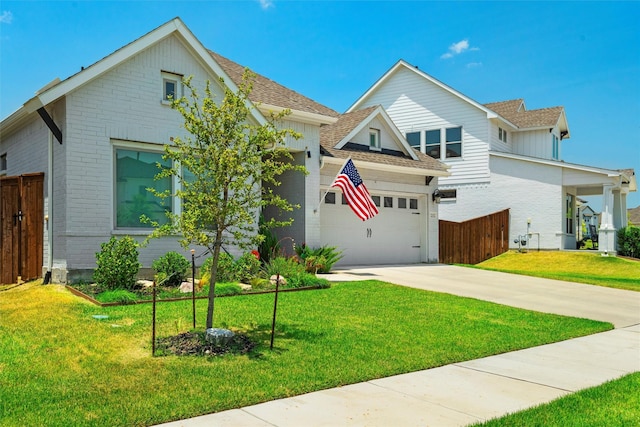 view of front facade with fence, concrete driveway, a front yard, a garage, and brick siding