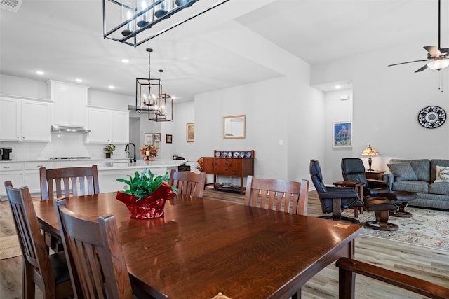 dining room with ceiling fan, sink, and light hardwood / wood-style floors