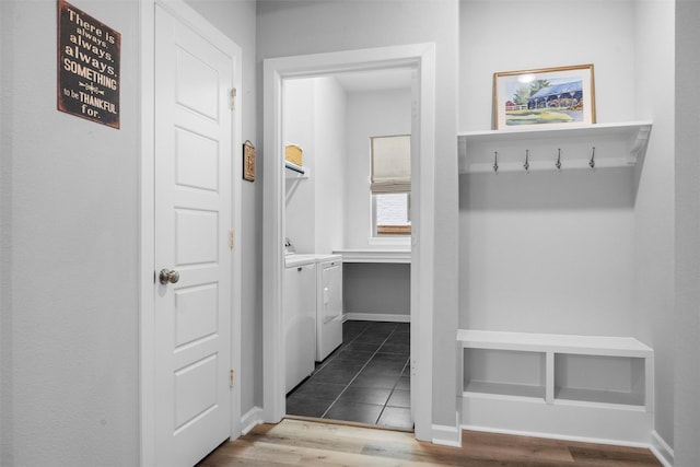 mudroom featuring washer and dryer, baseboards, and dark wood-type flooring