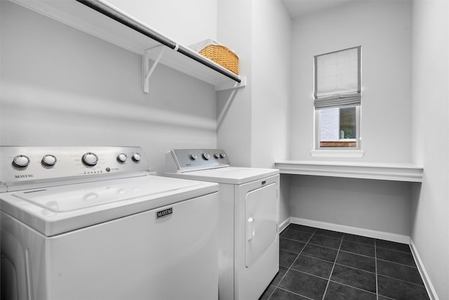 washroom featuring laundry area, dark tile patterned floors, baseboards, and independent washer and dryer