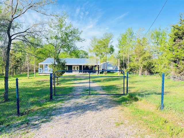 view of gate with a yard