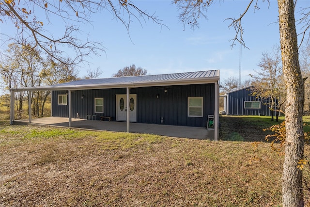 rear view of property featuring a patio and a yard