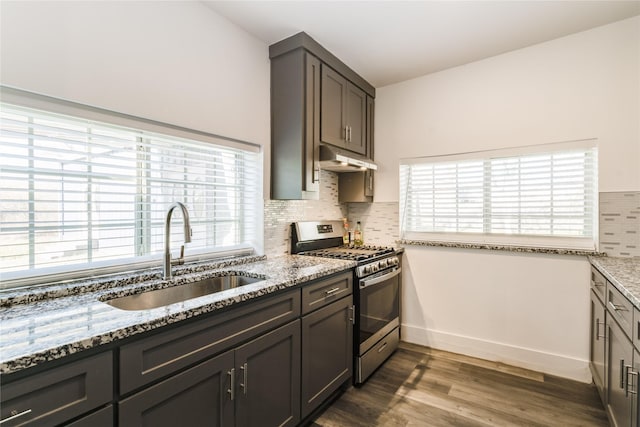 942 County Road 2240, Corsicana, TX 75109 - kitchen with stainless steel gas range oven, a sink, light stone counters, under cabinet range hood, and dark wood-style floors