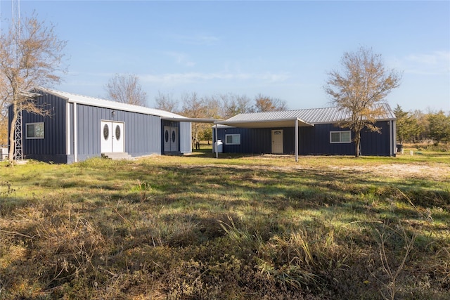 942 County Road 2240, Corsicana, TX 75109 - back of property featuring board and batten siding, metal roof, entry steps, and a yard