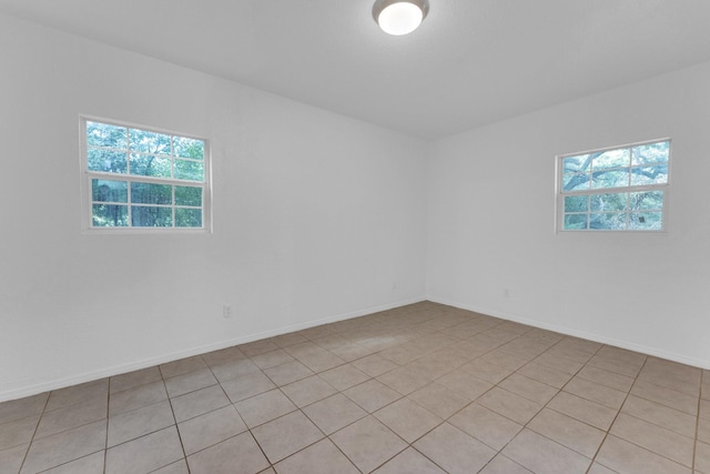 spare room with a wealth of natural light and light tile patterned floors