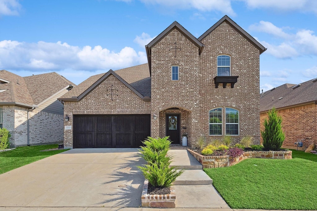 french provincial home with a garage and a front lawn