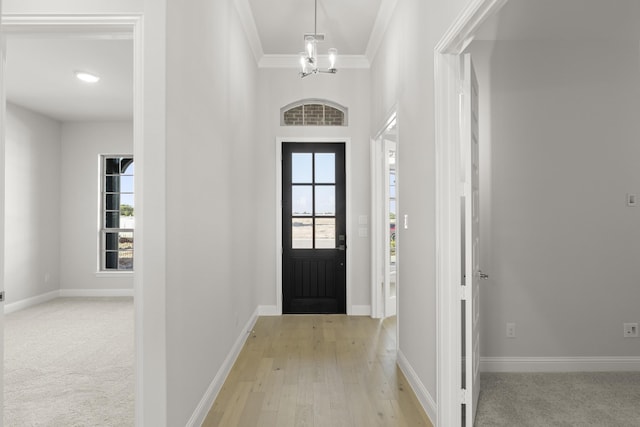 entrance foyer featuring light hardwood / wood-style flooring, crown molding, and a chandelier