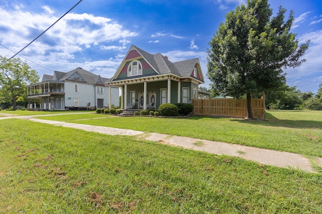 victorian-style house with a porch and a front lawn