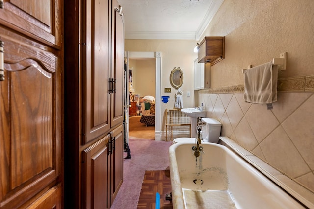 bathroom with crown molding and a bath