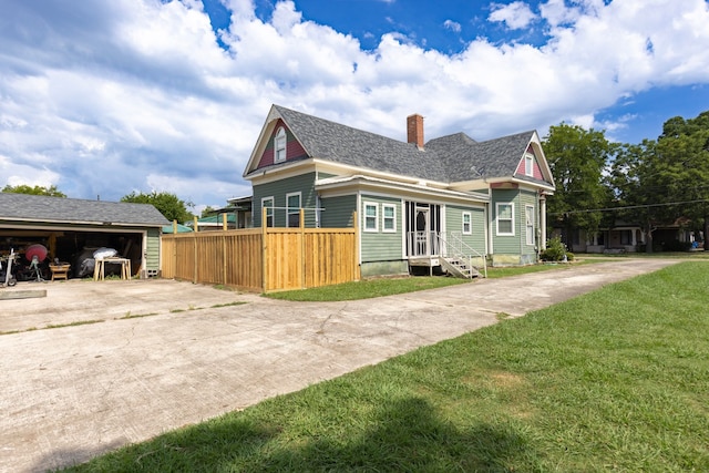 view of front of house with a front lawn, an outdoor structure, and a garage