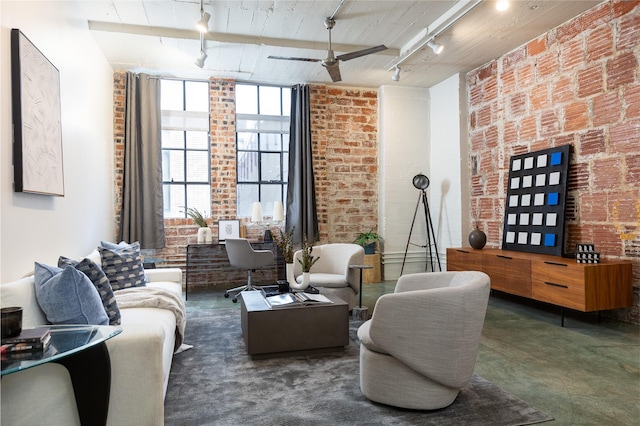 living room with ceiling fan, rail lighting, and brick wall