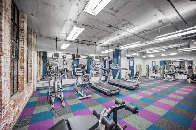 exercise room featuring brick wall