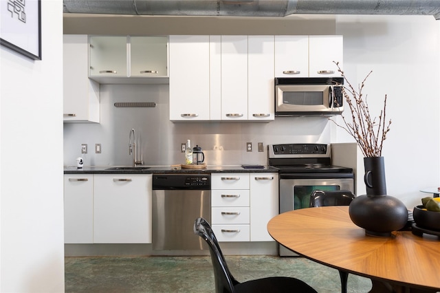 kitchen featuring stainless steel appliances, white cabinetry, and sink