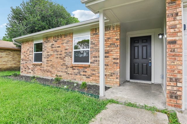 entrance to property with a lawn