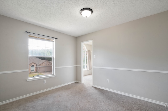 carpeted empty room with a textured ceiling