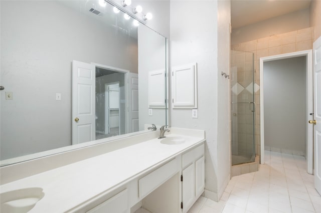 bathroom featuring tile patterned floors, a shower with door, and double sink vanity