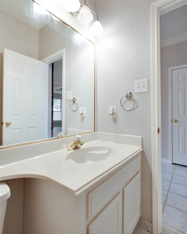 bathroom with tile patterned floors, vanity, crown molding, and toilet