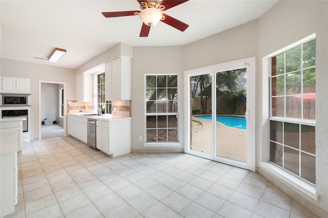 kitchen featuring white cabinetry, stainless steel appliances, light tile patterned floors, and ceiling fan