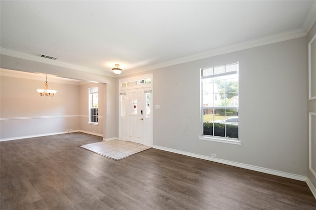 entryway featuring an inviting chandelier, crown molding, and dark wood-type flooring