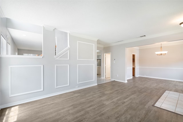 unfurnished living room featuring light hardwood / wood-style floors, a notable chandelier, and ornamental molding