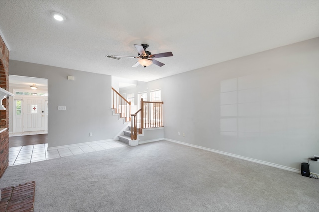 unfurnished living room featuring a textured ceiling, light colored carpet, and ceiling fan