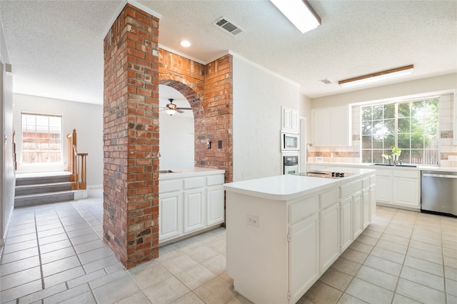 kitchen featuring light tile patterned floors, a wealth of natural light, appliances with stainless steel finishes, and a kitchen island