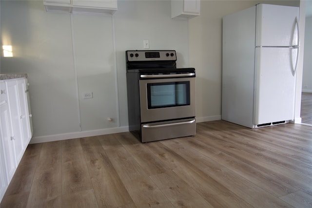 kitchen with white cabinetry, white fridge, light hardwood / wood-style flooring, and stainless steel electric range