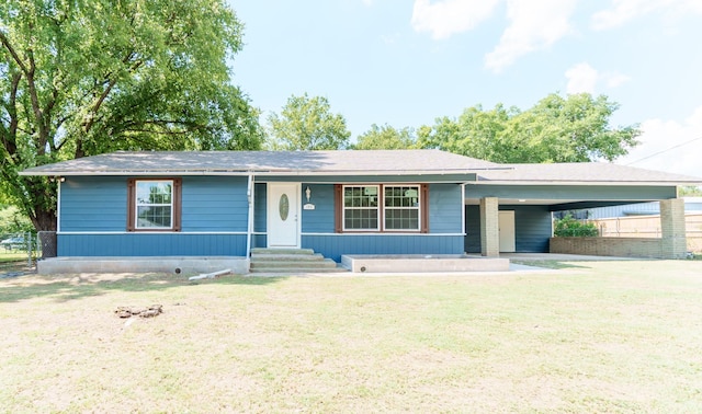 ranch-style house with a carport and a front lawn