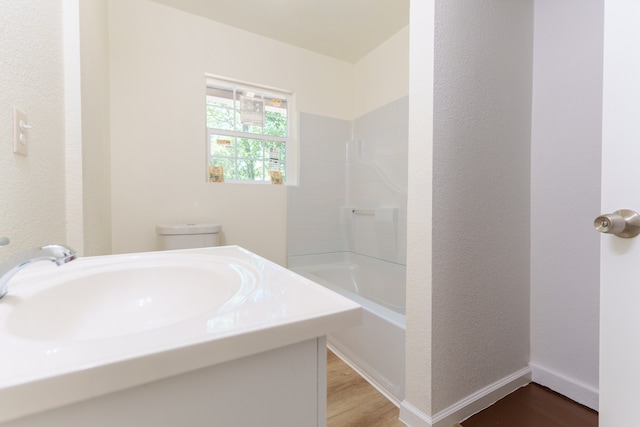 full bathroom featuring hardwood / wood-style flooring, sink, shower / bathtub combination, and toilet