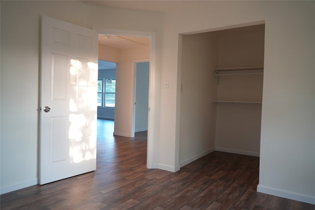 unfurnished bedroom with dark hardwood / wood-style floors and a closet