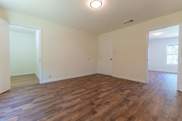 unfurnished room with dark hardwood / wood-style flooring