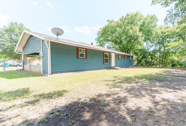 rear view of property featuring a lawn