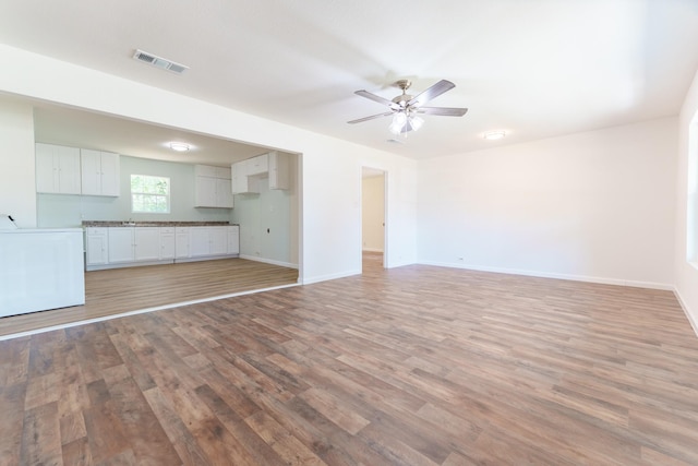 unfurnished living room with light hardwood / wood-style floors and ceiling fan