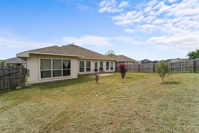 rear view of property with a yard